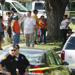 Residents watch as Salt Lake City police officers investigate a dead body found Monday, June 1, 2015, along the Jordan River Parkway Trail near 804 N. Riverside Drive.