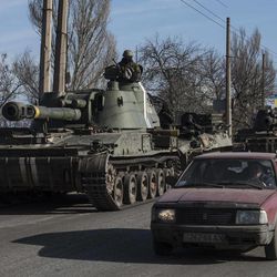 Ukrainian troops ride on self-propelled artillery near Artemivsk, eastern Ukraine, Monday, Feb. 23, 2015. A Ukrainian military spokesman says continuing attacks from rebels are delaying Ukrainian forces' pullback of heavy weapons from the front line in the country's east. 