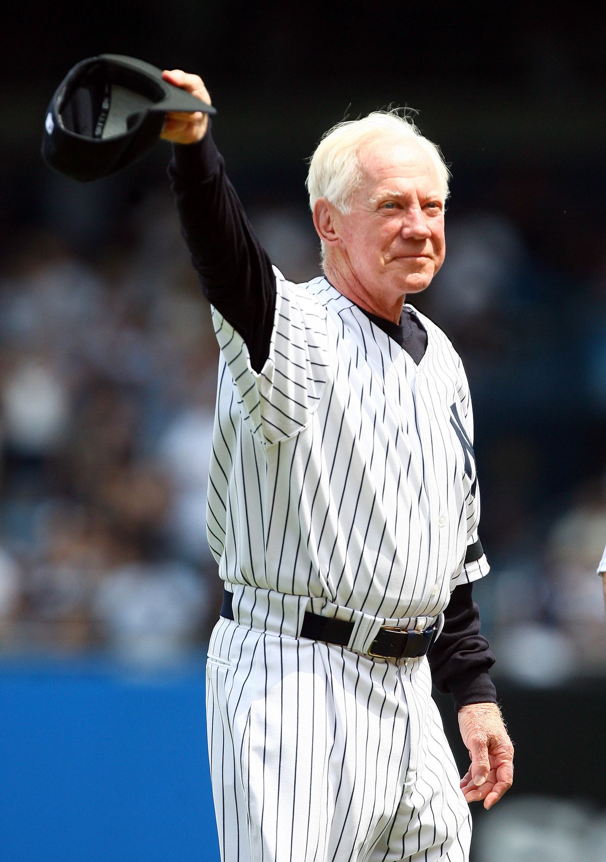 Former New York Yankees’ pitcher Whitey Ford tips his hat to
