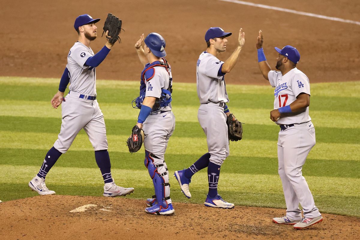 Cody Bellinger #35, Will Smith #16, Chris Taylor #3 and Hanser Alberto #17 of the Los Angeles Dodgers celebrate after defeating the Arizona Diamondbacks in MLB game at Chase Field on September 12, 2022 in Phoenix, Arizona. The Dodgers defeated the Diamondbacks 6-0.