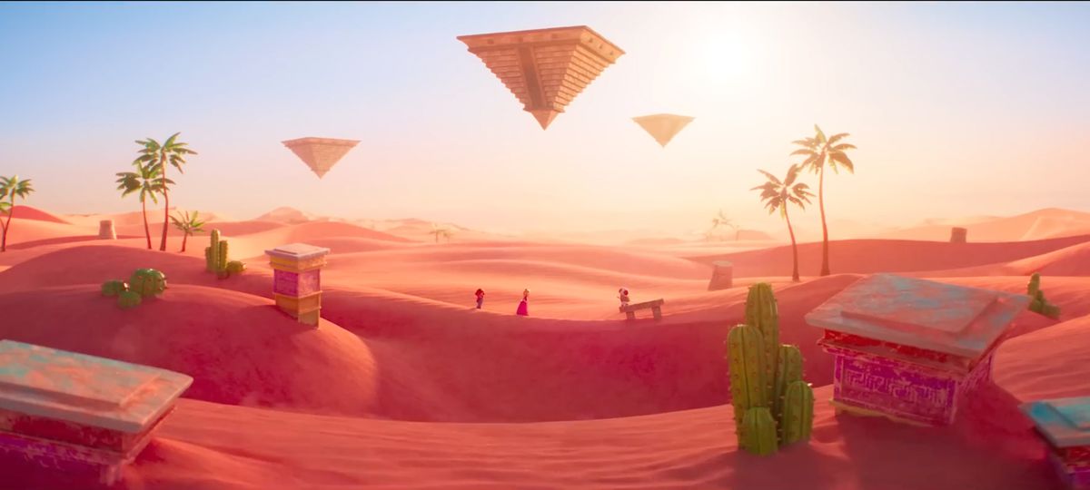 Una toma de paisaje del Reino de Arena de The Super Mario Bros. Movie.  Mario, Peach y Toad cruzan una duna de arena al fondo.