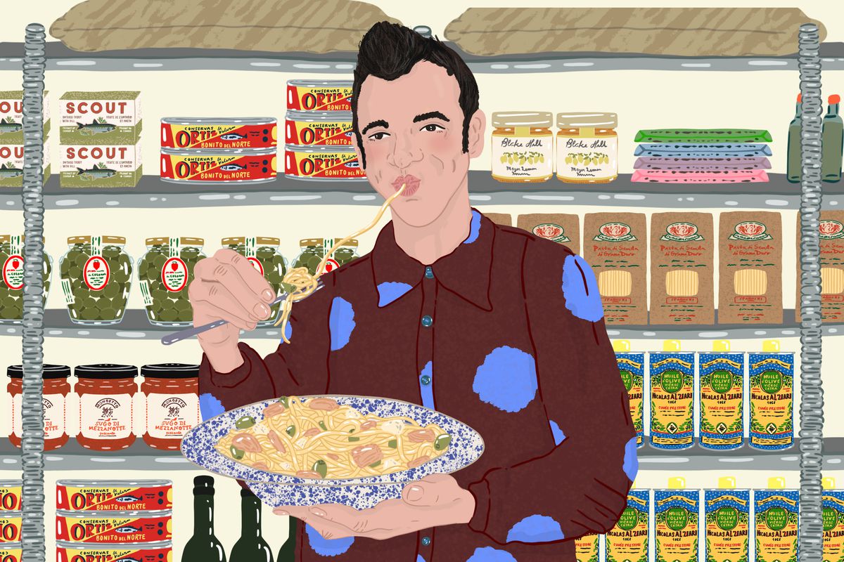 Brad Hedeman eats a big bowl of pasta in front of shelves lined with bottles of olive oil, boxes of pasta, tins of Ortiz tuna, and jars of olives. Illustration.