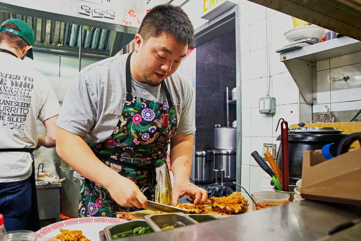 Eric Sze, chef and co-owner of Taiwanese restaurants Wenwen and 886, prepares chicken in the kitchen.