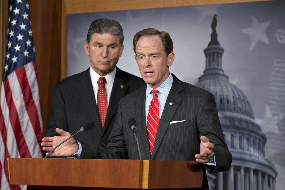 In this April 10, 2013 file photo, Democratic Sen. Joe Manchin of West Virginia, left, and Republican Sen. Patrick Toomey of Pennsylvania, right, announce that they have reached a bipartisan deal on expanding background checks to more gun buyers, at the C