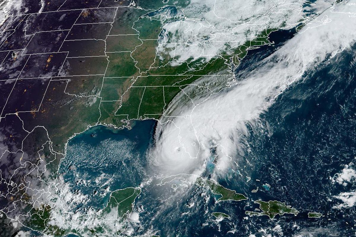 A satellite image of a white swirling spiral-shaped hurricane over the Gulf of Mexico as it approaches Florida.