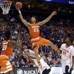 Syracuse's Malachi Richardson (23) is fouled on his way to the basket by Dayton's Dyshawn Pierre as Syracuse's Tyler Roberson (21) and Dayton's Scoochie Smith (11) watch during the second half in a first-round men's college basketball game in the NCAA tournament on March 18, in St. Louis. Syracuse won 70-51. (AP Photo/Jeff Roberson)