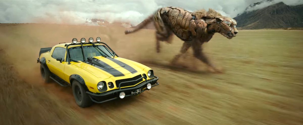 Bumblebee под формата на офроуд превозно средство и Chittoor, леко роботизиран гепард, се състезават през открито поле в Transformers: Rise of the Beasts