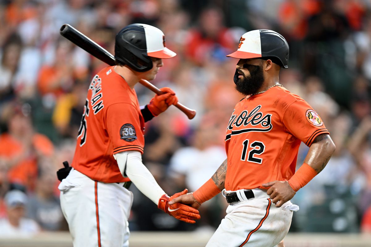Rougned Odor #12 of the Baltimore Orioles celebrates with Adley Rutschman #35 after scoring in the seventh inning against the Pittsburgh Pirates at Oriole Park at Camden Yards on August 06, 2022 in Baltimore, Maryland.