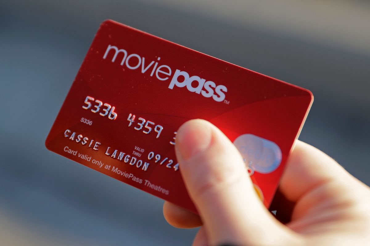 FILE - In this Jan. 30, 2018 file photo, Cassie Langdon holds her MoviePass card outside AMC Indianapolis 17 theatre in Indianapolis. The startup that lets customers watch a movie a day at theaters for just $10 a month, is limiting new customers to just f