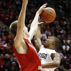 San Diego State's Brian Carlwell (5) shoots over Utah's 7-foot defender David Foster (51) in the first half of Saturday's Mountain West Conference clash at Viejas Arena. __Utah's Luka Drca (5) puts up a shot over the outstretched hand of San Diego State's Kawhi Leonard (15). 