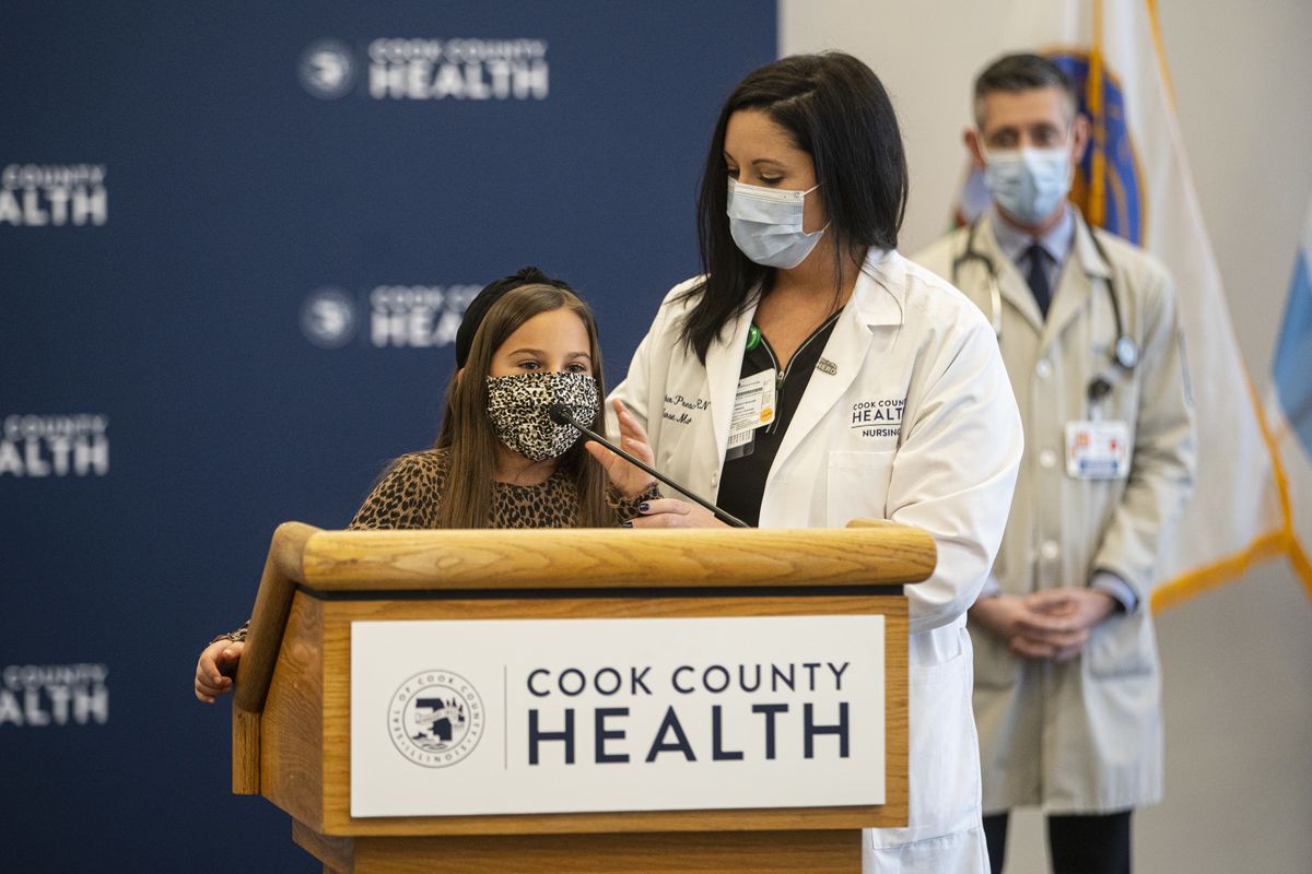 Mia Lopez, 7, speaks at a news conference Monday, Nov. 23, 2020 organized by Cook County Health. With her is her mom, Heather Prescaro, an emergency department nurse. They and other Cook County Health staff are asking residents to stay at home for Thanksgiving to limit the spread of the coronavirus.