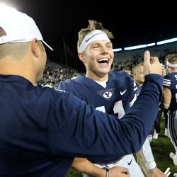 Brigham Young Cougars quarterback Zach Wilson (11) celebrates the win with Offensive Line Coach Ryan Pugh as BYU defeats Hawaii at LaVell Edwards Stadium 49-23 in Provo on Saturday, Oct. 13, 2018.