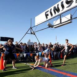 American Fork High School’s Ashton Hysell dives over the finish line to win the boys varsity 5K during the BYU Autumn Classic Cross Country Invitational at the East Bay Golf Course Saturday, Sept. 14, 2019 in Provo. Stansbury High’s Carson Belnap, right, took second place.