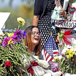 Marjory Stoneman Douglas High School former student Ariana Gonzalez weeps at a cross of slain Marjory Stoneman Douglas coach Aaron Feis, on a hill honoring those killed, Friday, Feb. 23, 2018, in Parkland, Fla. Teachers and staff returned to the school, to begin to organize and prepare to welcome students next week. Over a dozen students and teachers were killed on Valentine's Day in a mass shooting at the high school. (Charles Trainor Jr./)
