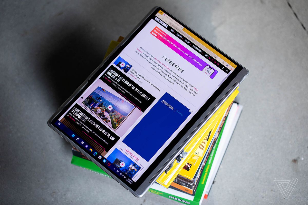 Das Lenovo Yoga 9i im Tablet-Modus auf einem Stapel Bücher.