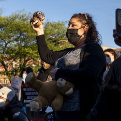 Garciela Garcia offers a Chicago police officer a stuffed animal as a peace offering outside the Chicago Police Training Academy, Friday, April 30, 2021.