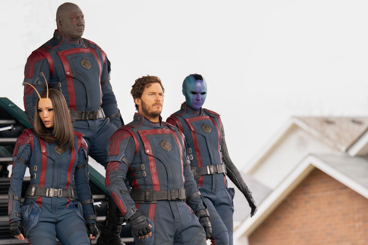 The Guardians of the Galaxy in their Nova uniforms walk down a spaceship stairs into a suburban neighborhood in Guardians of the Galaxy Vol. 3