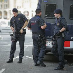 Armed police officers stand next to their van in Las Ramblas, in Barcelona, Spain, Friday, Aug. 18, 2017. A white van jumped up onto a sidewalk and sped down a pedestrian zone Thursday in Barcelona's historic Las Ramblas district, swerving from side to side as it plowed into tourists and residents. Police said 13 people were killed and more than 50 wounded in what they called a terror attack.
