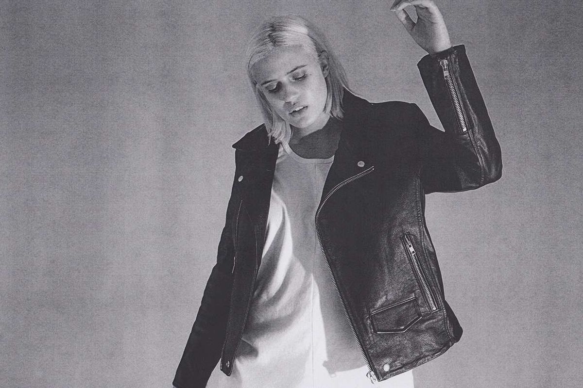 A blonde plus-size woman wears a leather jacket