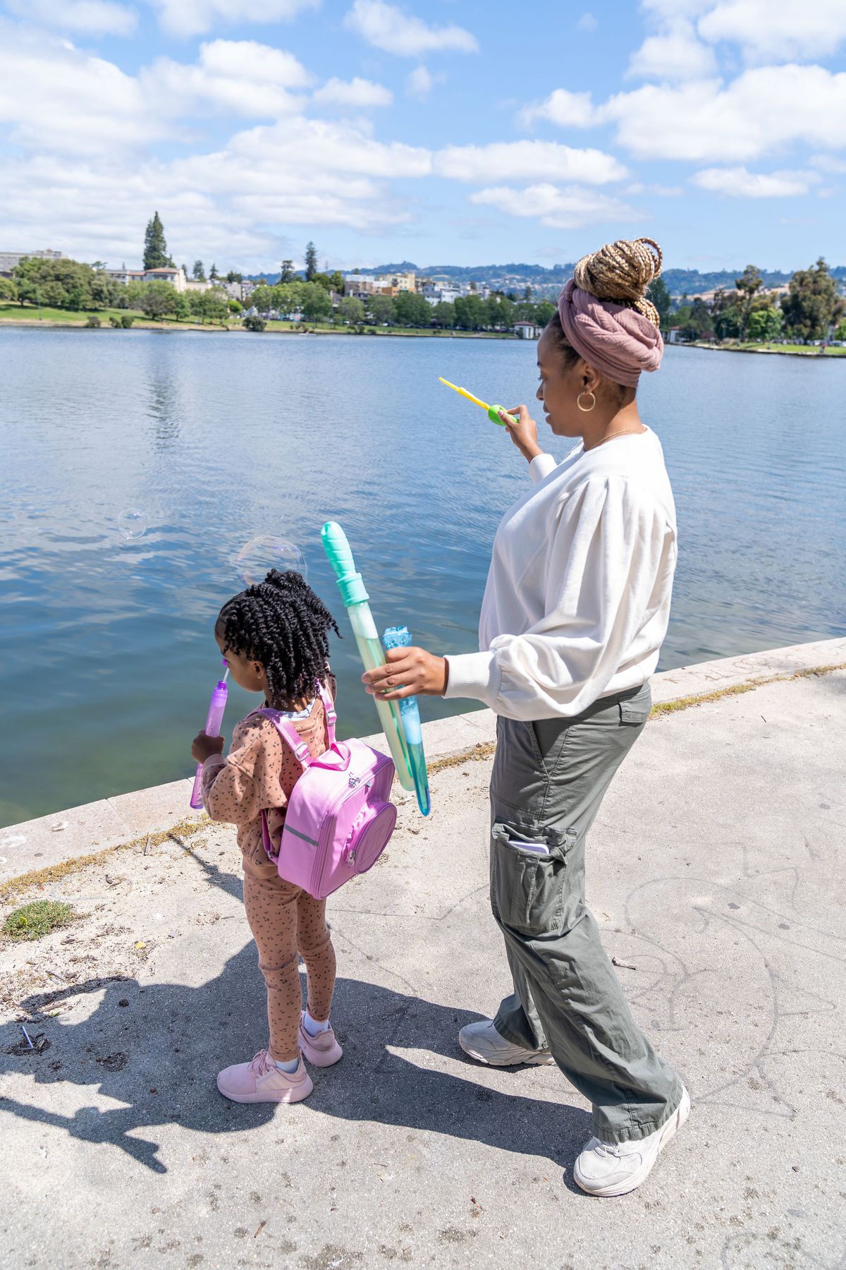 Stephanie McWoods blowing bubbles with her daughter at the edge of Lake Merritt in Oakland, California.