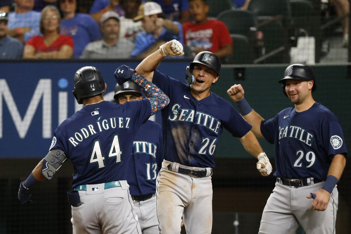 Julio Rodriguez #44 of the Seattle Mariners celebrities with teammates Abraham Toro #13, Adam Frazier #26 and Cal Raleigh #29 after hitting a grand slam home run against the Texas Rangers during the eighth inning at Globe Life Field