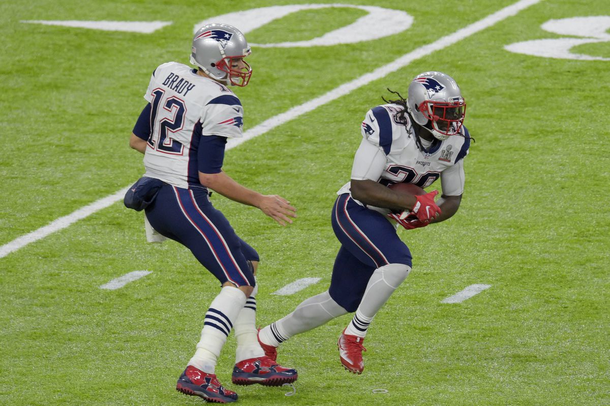 LeGarrette Blount #29 of the New England Patriots take the handoff from Tom Brady #12 against the Atlanta Falcons during Super Bowl 51 at NRG Stadium on February 5, 2017 in Houston, Texas. The Patriots defeat the Atlanta Falcons 34-28 in overtime.