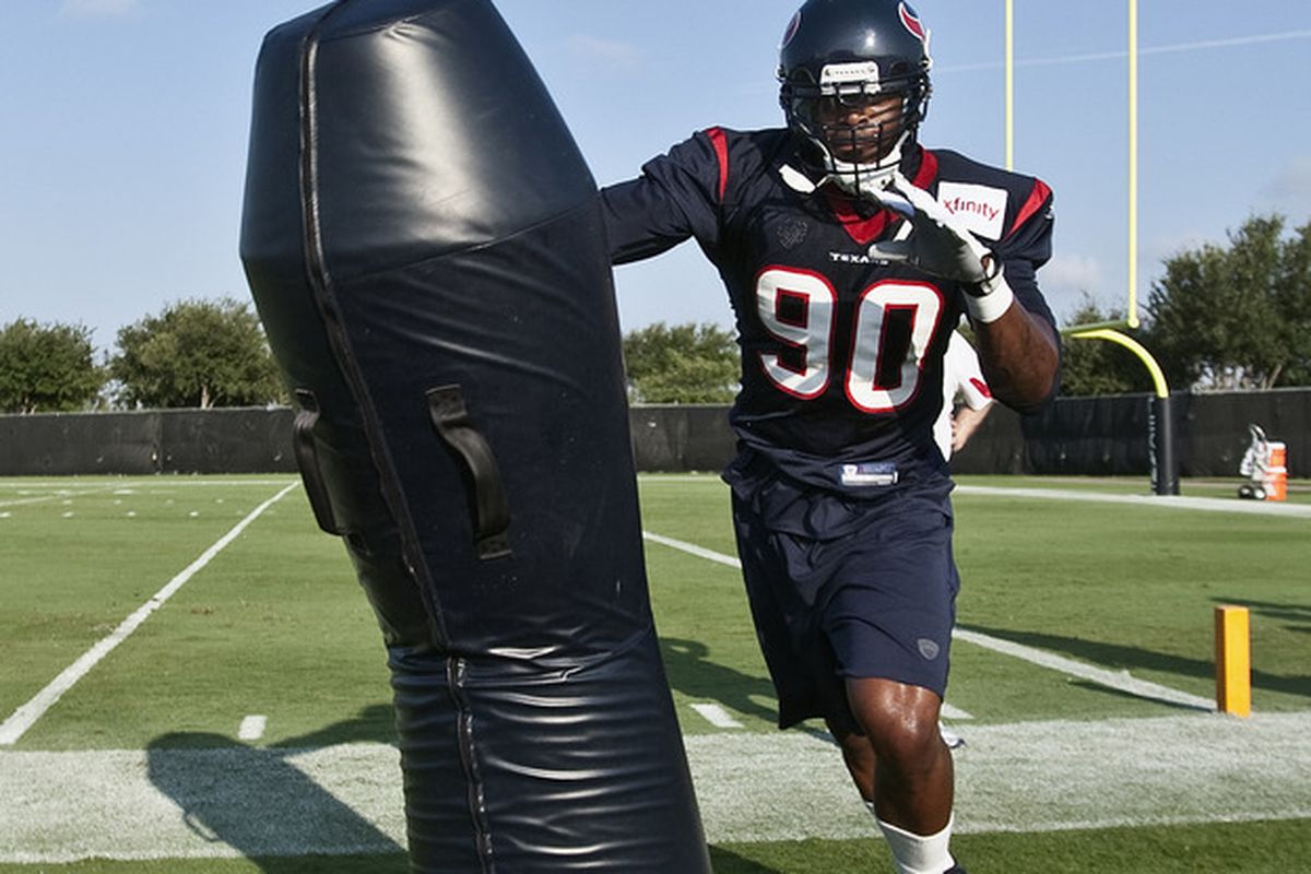 HOUSTON, TX - AUGUST 01:  Outside linebacker Mario Williams #90 of the Houston Texans hits the tackling dummy during practice on the first day of training camp at Reliant Park on August 1, 2011 in Houston, Texas.  (Photo by Bob Levey/Getty Images)