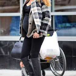 In two plaid jackets, a Gucci bag, and a newsboy cap on December 11, 2014.
