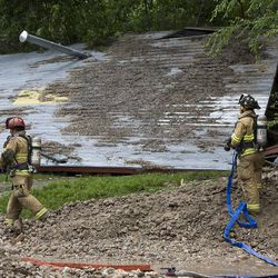 Fire crews attempt to search a home that collapsed at 915 Canyon Road after a canal break sent water and debris into the area in Logan, Saturday, July 11, 2009. 

