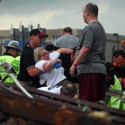 Emergency workers pull out a woman that was trapped in a building that was destroyed off of 4th Street and Interstate 35 after a tornado ripped through Moore, Okla.,  Monday May 20, 2013. 