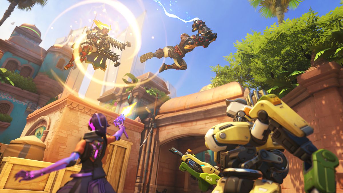 Illari uses her ultimate ability while Sombra and Bastion look upward at her in a screenshot from Overwatch 2