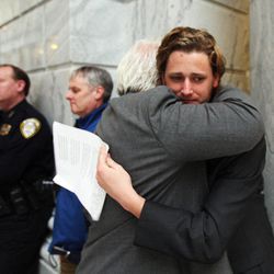 Court Einfeldt, who lost his sister to domestic violence, hugs Ned Searle of Mens Antiviolence Network following a press conference held by the Utah Domestic Violence Coalition at the Capitol in Salt Lake City, Monday, Feb. 9, 2015.