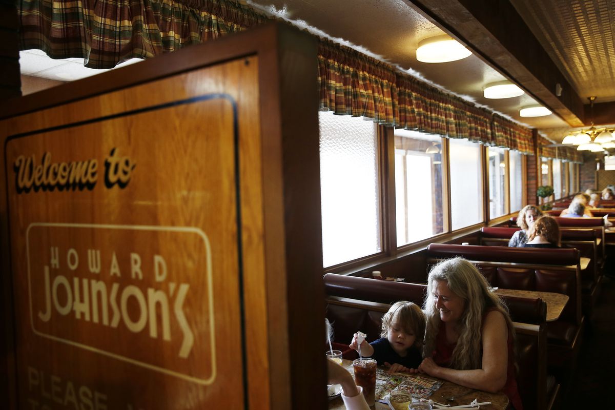 A woman keeps her two-year-old grandson, Lincoln, occupied as they waited for their meals to arrive at the Howard Johnson’s restaurant in Bangor, Maine, on Aug. 31, 2016.
