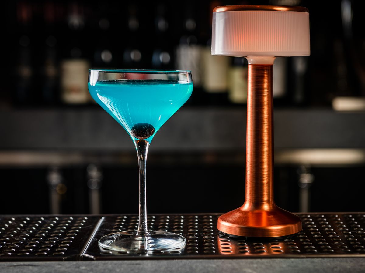 A blue martini sitting on a bar