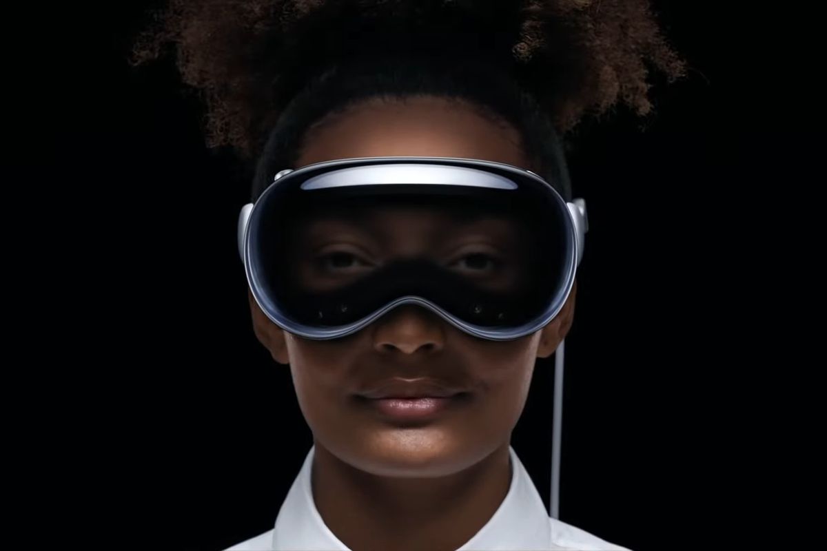 The image shows a user wearing the Apple Vision Pro headset. The headset can show the user’s eyes thanks to internal cameras.