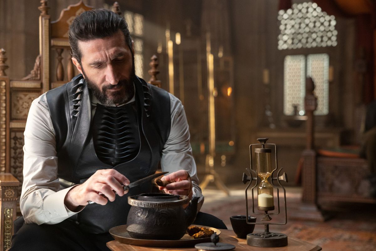 Ishamael (Fares Fares) sitting and playing with a knife
