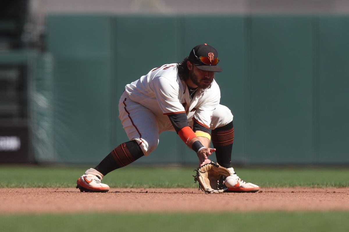 Brandon Crawford bending over to field a grounder