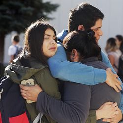 A family hugs as they reunite outside Mountain View High School in Orem on Tuesday, Nov. 15, 2016, following a stabbing at the school.