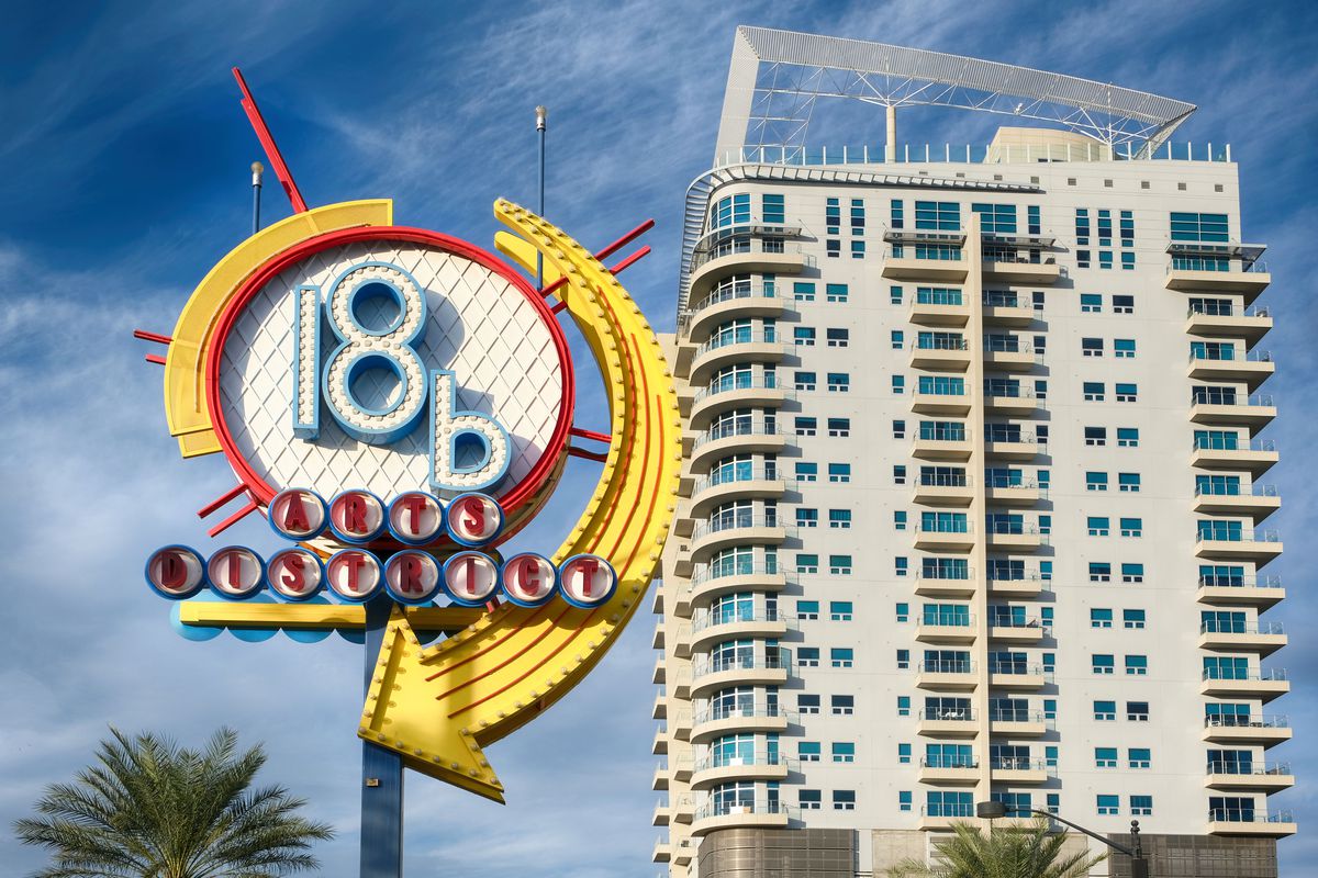 A round neon sign with an apartment tower in the background