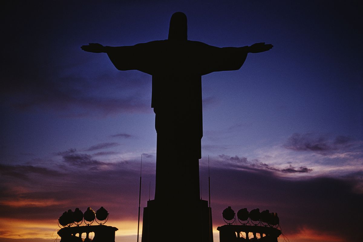 Christ the Redeemer, the giant statue of Jesus Christ with his arms spread open, seen in silhouette at dusk