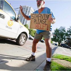 Steve Ray Evans, pictured in downtown Salt Lake City in the summer of 2013, panhandles near the Little America Hotel.