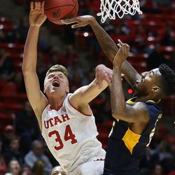 Utah's Jayce Johnson (34) gets fouled by Coppin State's Terry Harris Jr. (25) at the Huntsman Center at the University of Utah in Salt Lake City on Friday, Nov. 18, 2016.