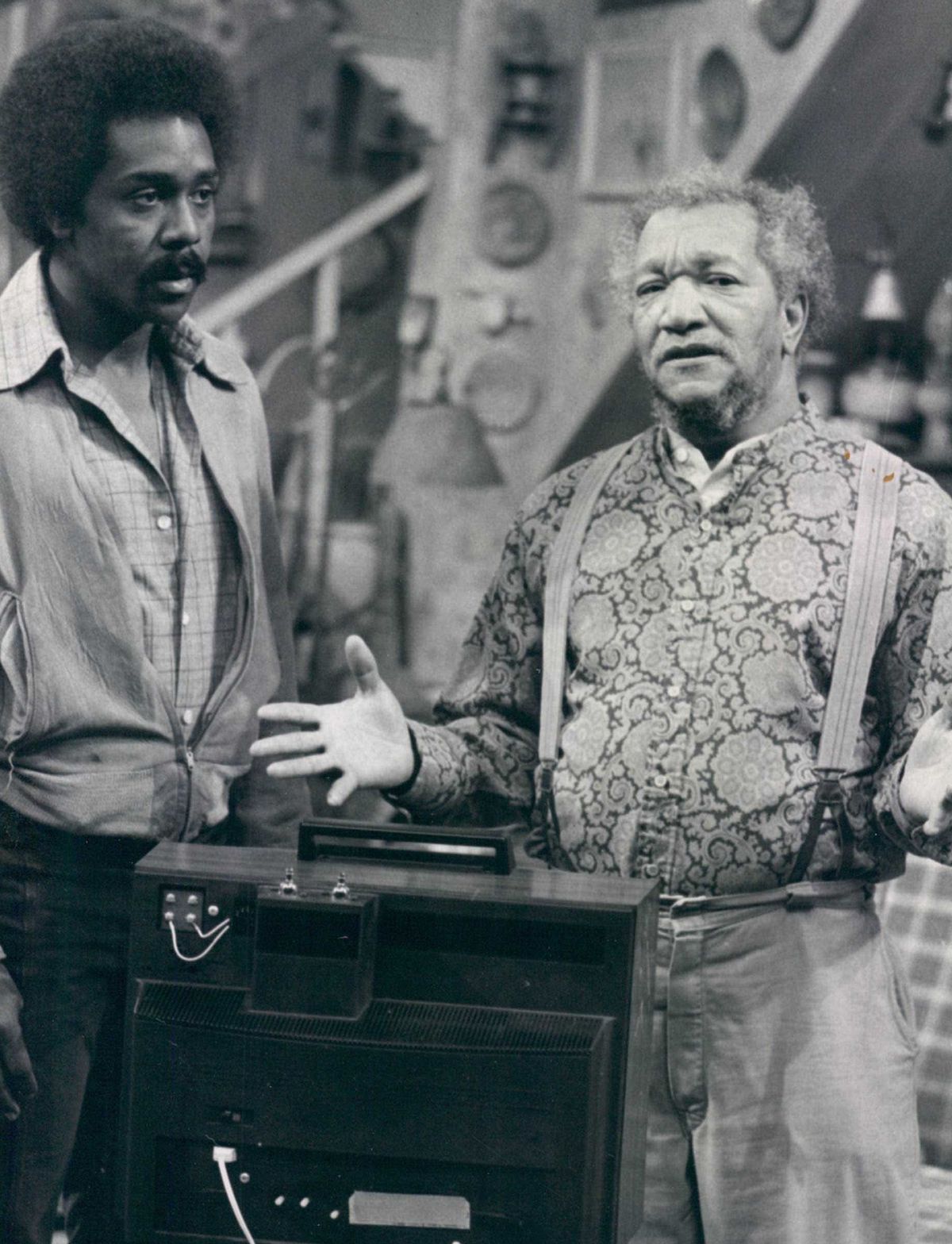 Fred Sanford (Redd Foxx, right) has an explanation for his son Lamont (Demond Wilson) about the TV set he has landed in a deal which in turn lands him in a spot of trouble in “This Little TV Went to Market,” episode of “Sanford and Son” in 1973. 