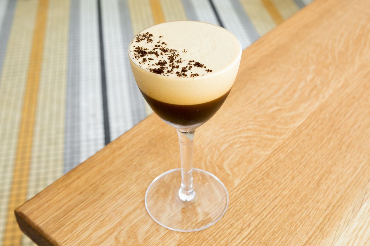 A espresso martini on a wooden table.