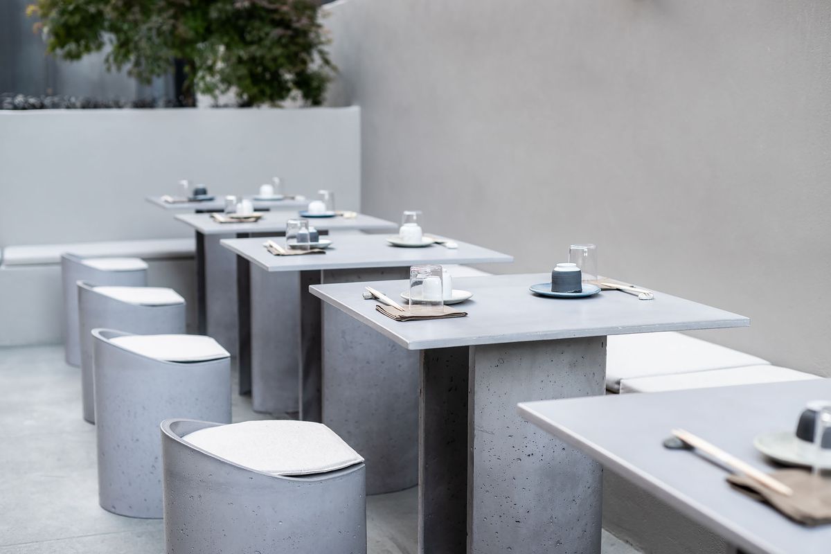 A low look at a run of grey tables at a new restaurant patio.