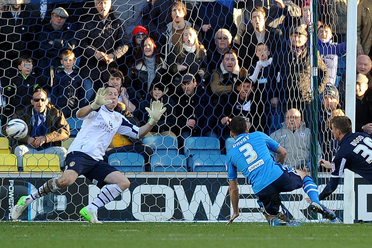 Millwall's Christ Wood shoots past Paddy Kenny for the match-winning goal.