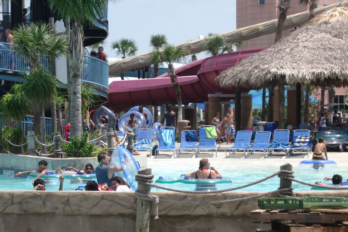 People in swimming pool with tiki-like background structure