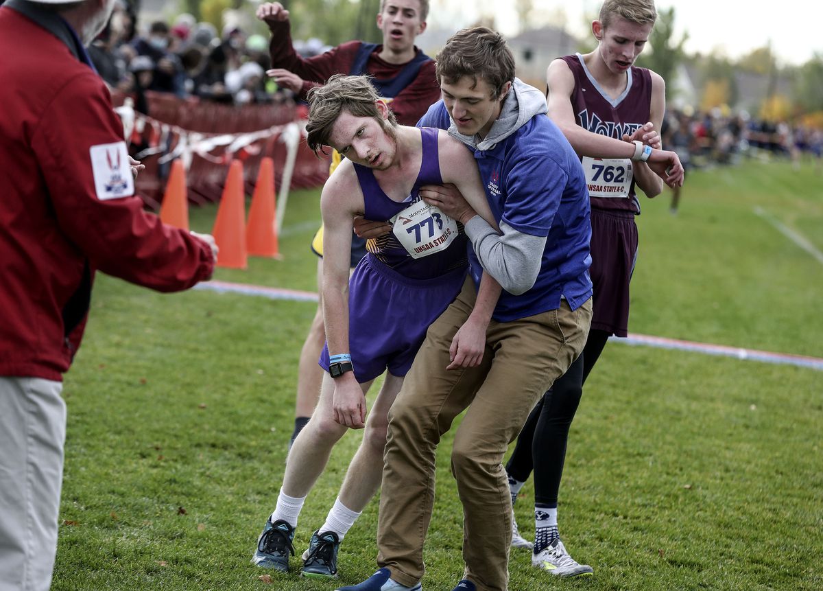 North Summit’s Daniel Dudley is assisted after crossing the finish line in the 2A boys cross-country state championships at the Regional Athletic Complex in Salt Lake City on Wednesday, Oct. 27, 2021.