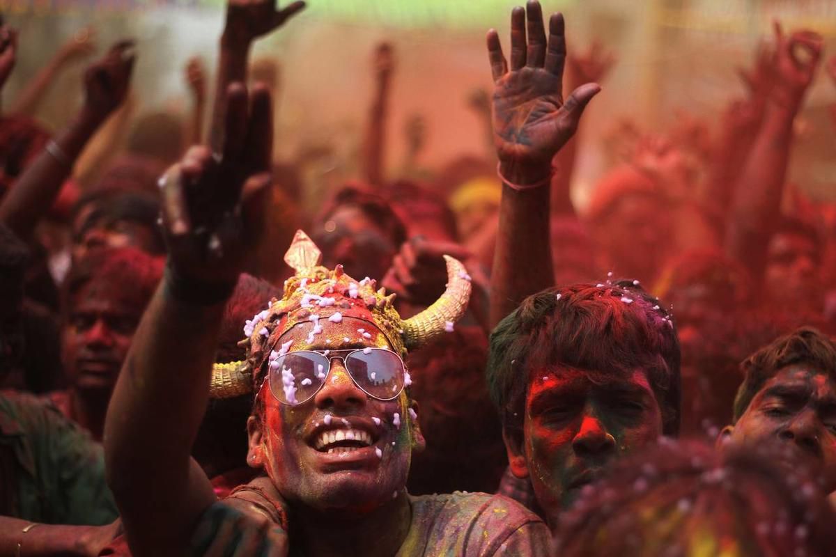 Indians, faces smeared with colored powder and foam, dance during celebrations marking Holi, the Hindu festival of colors, in Gauhati, India, Monday, March 17, 2014. The festival also marks the advent of spring.