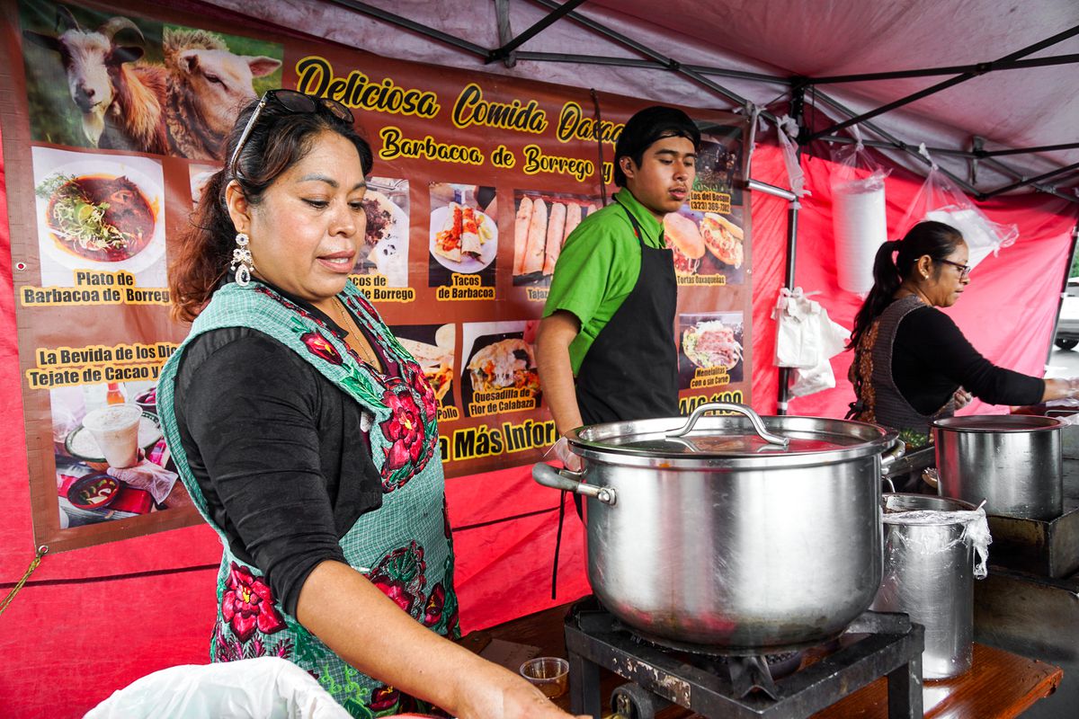 Three Oaxacan cooks make barbacoa and other snacks at a street stand.